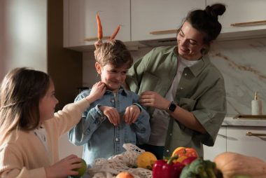 Mother and children have fun unpacking vegetables in the kitchen.